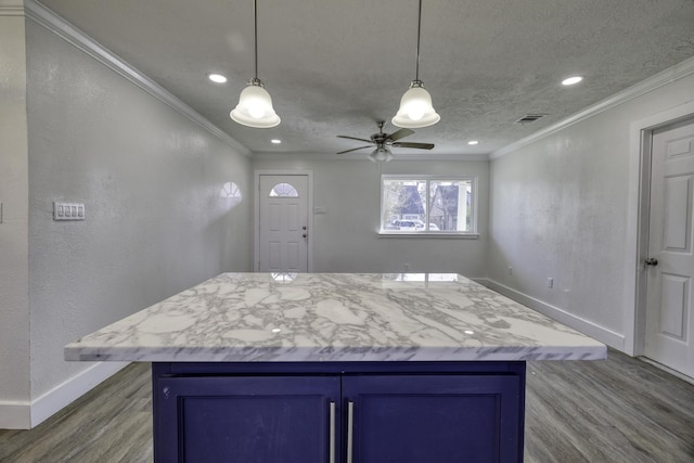 kitchen featuring wood finished floors, baseboards, crown molding, decorative light fixtures, and blue cabinets