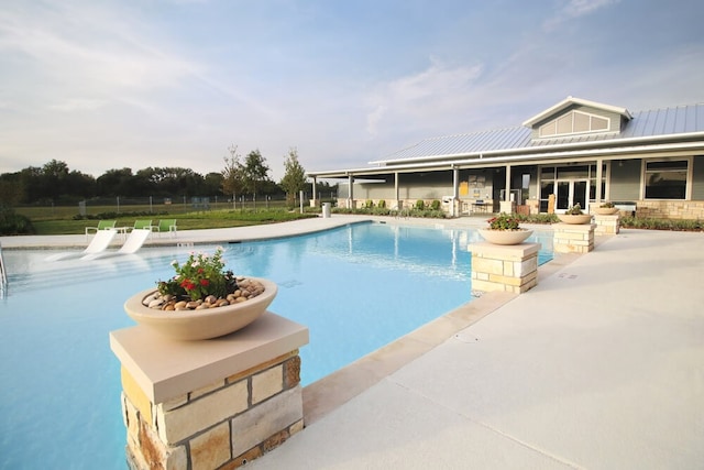 community pool with a patio and fence