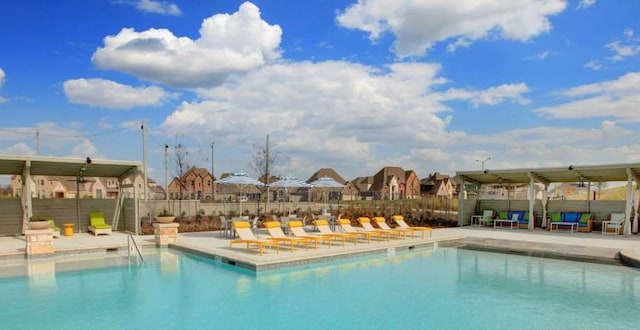 pool with a residential view, a patio area, and fence