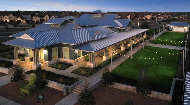 exterior space featuring a residential view, a patio area, metal roof, and a front lawn