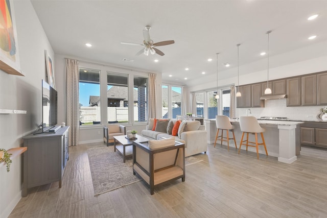 living room featuring light wood finished floors, visible vents, and recessed lighting