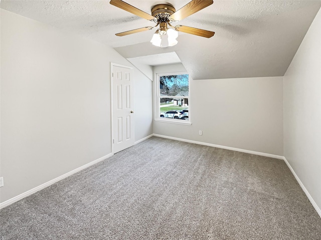 bonus room featuring carpet floors, a ceiling fan, vaulted ceiling, a textured ceiling, and baseboards