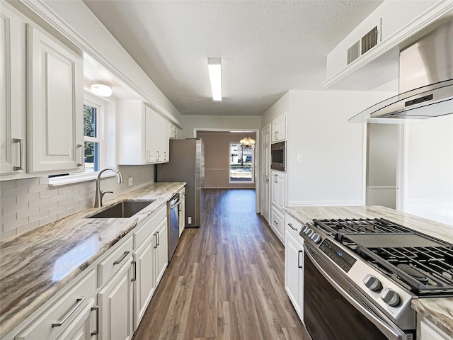 kitchen featuring appliances with stainless steel finishes, white cabinetry, a sink, and visible vents