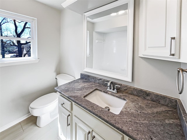 bathroom with baseboards, vanity, toilet, and tile patterned floors