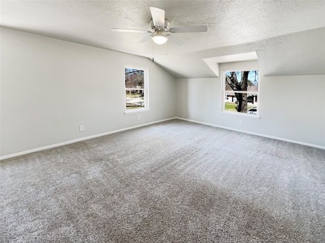 bonus room featuring a textured ceiling, carpet floors, and a wealth of natural light