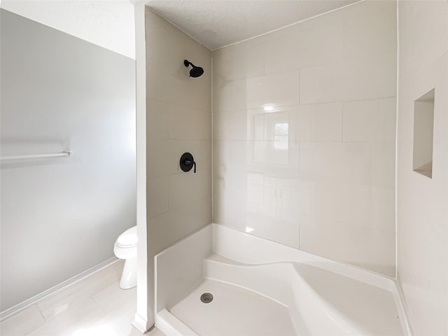 full bathroom with a shower, baseboards, and toilet