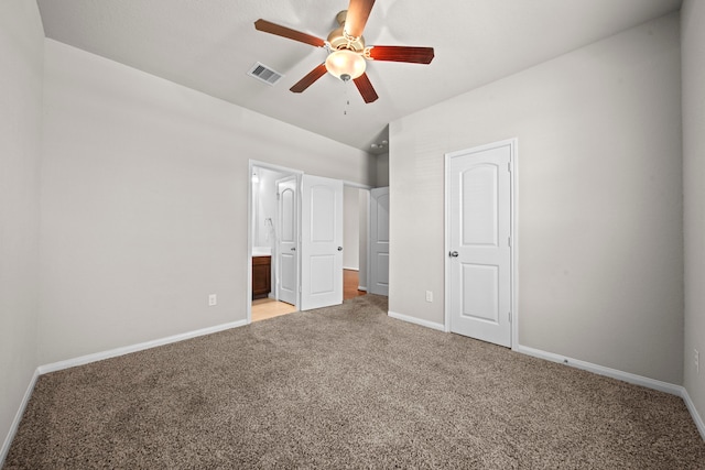 unfurnished bedroom with lofted ceiling, carpet flooring, visible vents, and baseboards