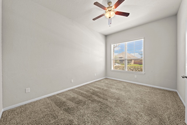 carpeted spare room featuring ceiling fan and baseboards