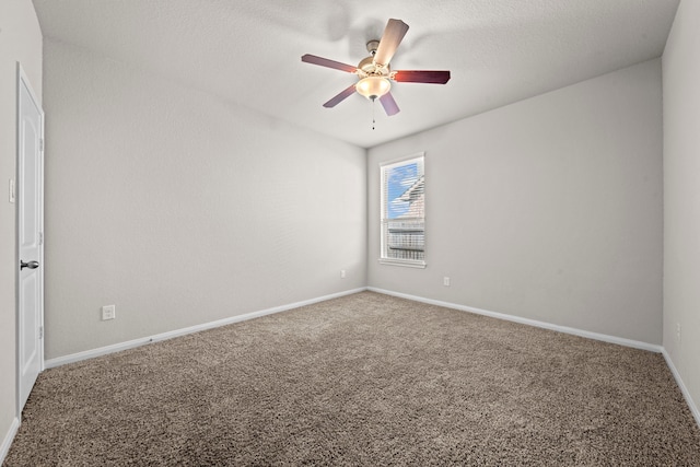 spare room with carpet floors, ceiling fan, and baseboards