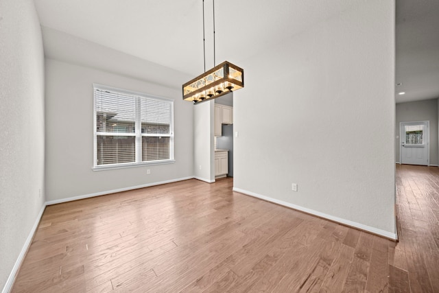 interior space featuring baseboards, plenty of natural light, and light wood-style floors