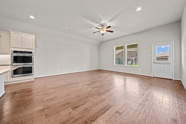 unfurnished living room with recessed lighting, visible vents, light wood-style floors, a ceiling fan, and baseboards