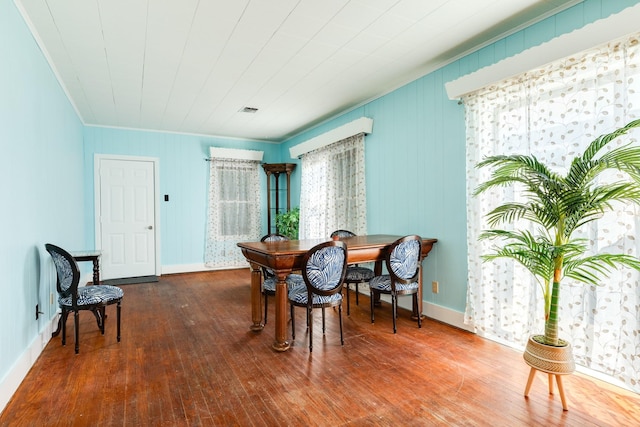 dining space with plenty of natural light, baseboards, and hardwood / wood-style floors