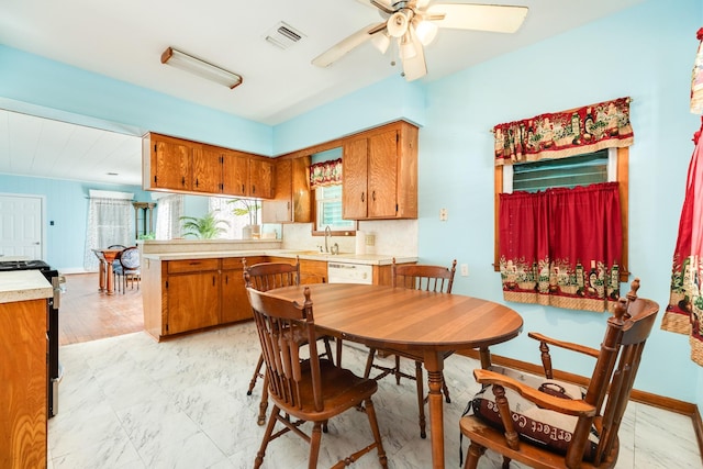 kitchen featuring light countertops, gas range oven, and brown cabinetry