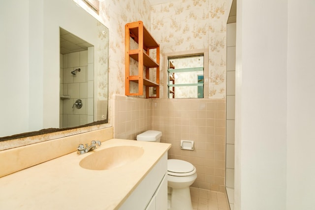 full bath featuring toilet, vanity, tile walls, walk in shower, and wallpapered walls