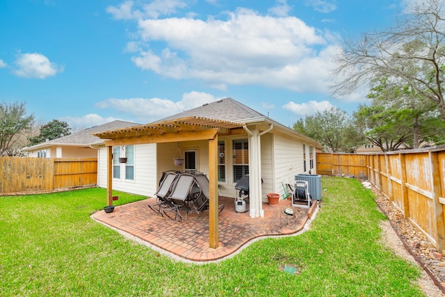 rear view of house featuring a fenced backyard, a yard, cooling unit, roof with shingles, and a patio area