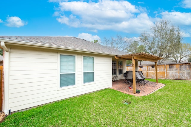 back of property featuring fence, roof with shingles, a lawn, a pergola, and a patio