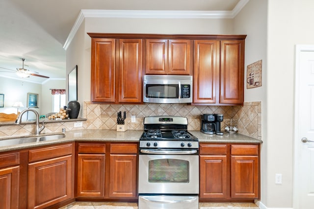 kitchen with ornamental molding, decorative backsplash, ceiling fan, a sink, and appliances with stainless steel finishes