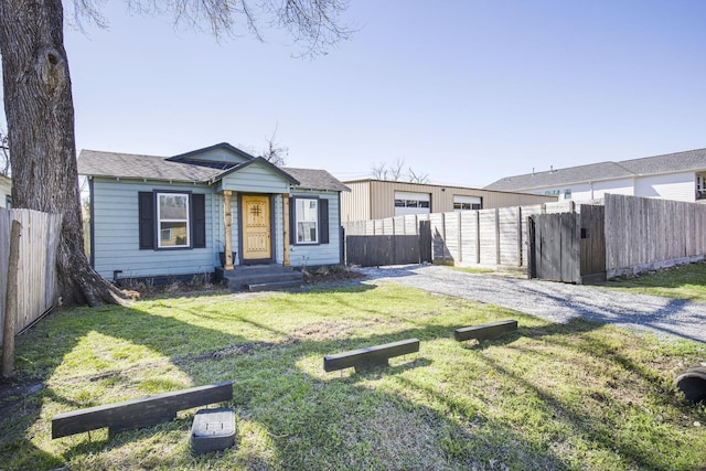 bungalow-style house with a gate, fence, and a front yard