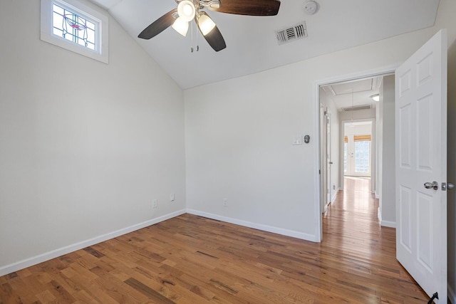 spare room with attic access, visible vents, baseboards, and wood finished floors