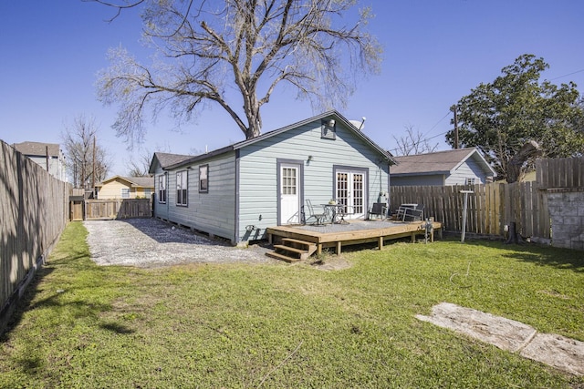 rear view of property featuring a fenced backyard, a deck, and a yard