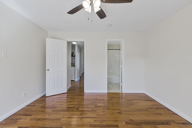 unfurnished bedroom featuring ensuite bathroom, washer / clothes dryer, wood finished floors, and baseboards