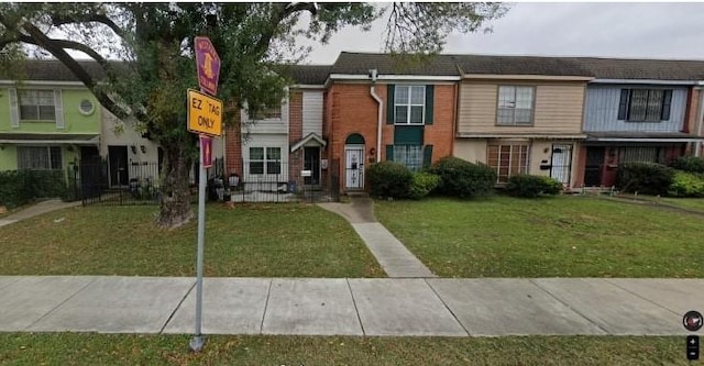 multi unit property with brick siding and a front lawn