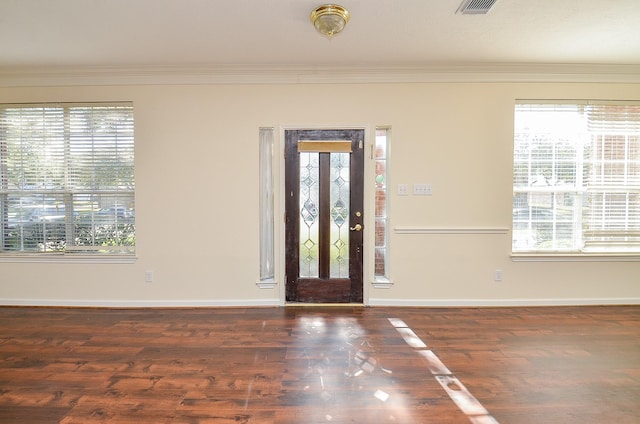 foyer with baseboards, ornamental molding, and wood finished floors