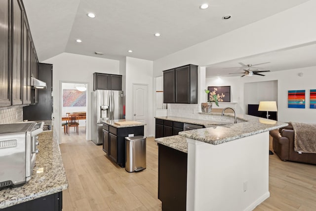 kitchen featuring light wood-type flooring, stainless steel appliances, a sink, and open floor plan