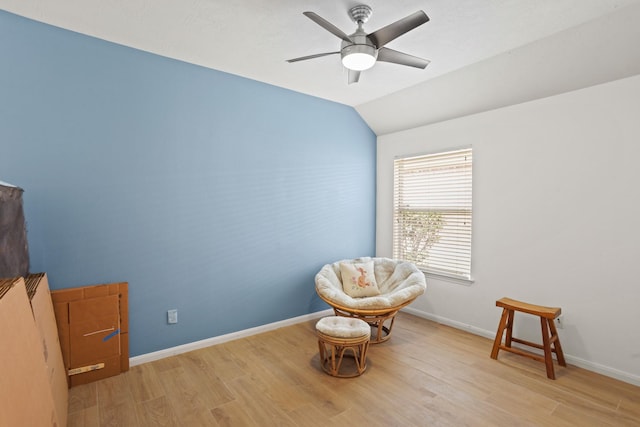 living area with light wood-type flooring, ceiling fan, lofted ceiling, and baseboards