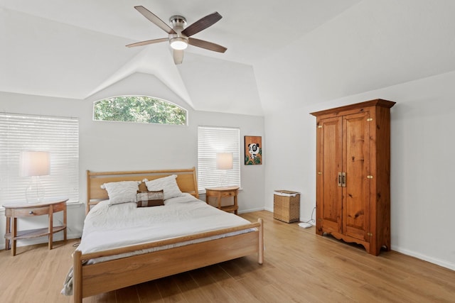 bedroom with lofted ceiling, light wood-type flooring, a ceiling fan, and baseboards