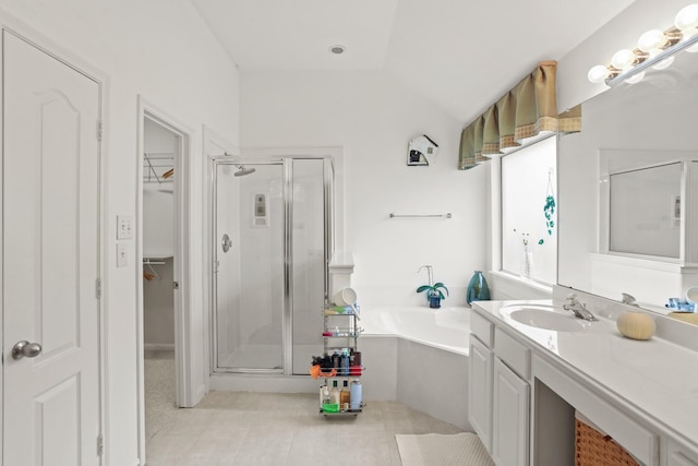 bathroom featuring lofted ceiling, a garden tub, vanity, a shower stall, and a walk in closet