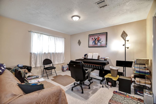 office space featuring baseboards, carpet, visible vents, and a textured ceiling