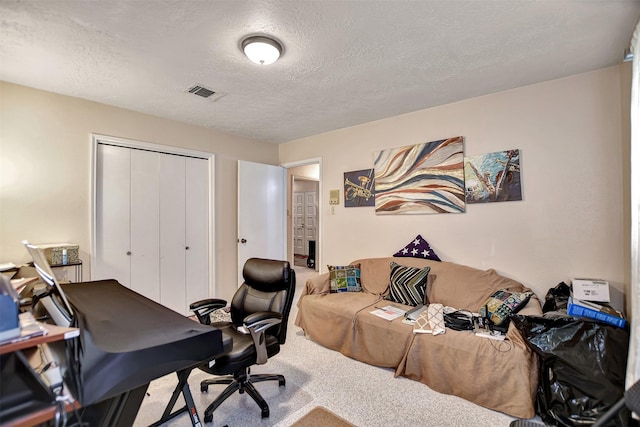 carpeted home office with visible vents and a textured ceiling