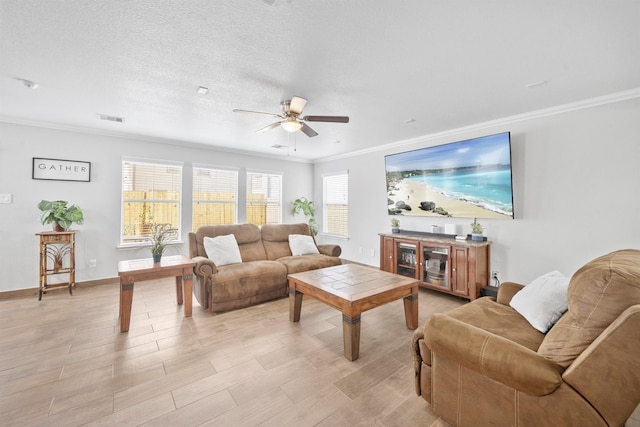 living room featuring baseboards, a textured ceiling, visible vents, and crown molding