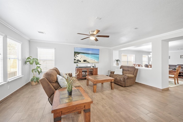 living room featuring light wood-type flooring, visible vents, crown molding, and baseboards