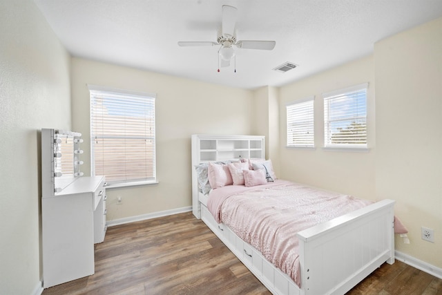 bedroom featuring visible vents, baseboards, and wood finished floors