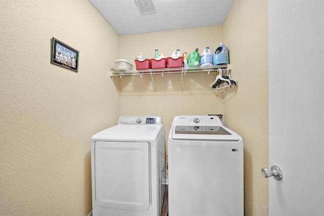 laundry area featuring laundry area, washing machine and dryer, and visible vents