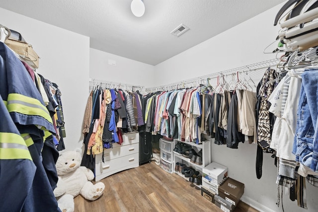 spacious closet featuring wood finished floors and visible vents