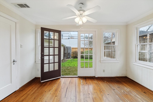 doorway with ceiling fan, ornamental molding, wood-type flooring, and visible vents