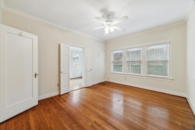 unfurnished room featuring ornamental molding, baseboards, and wood finished floors