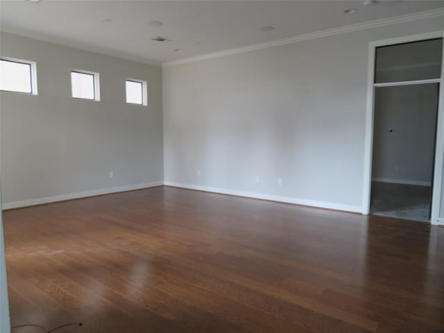 unfurnished room with dark wood-style floors, crown molding, and baseboards