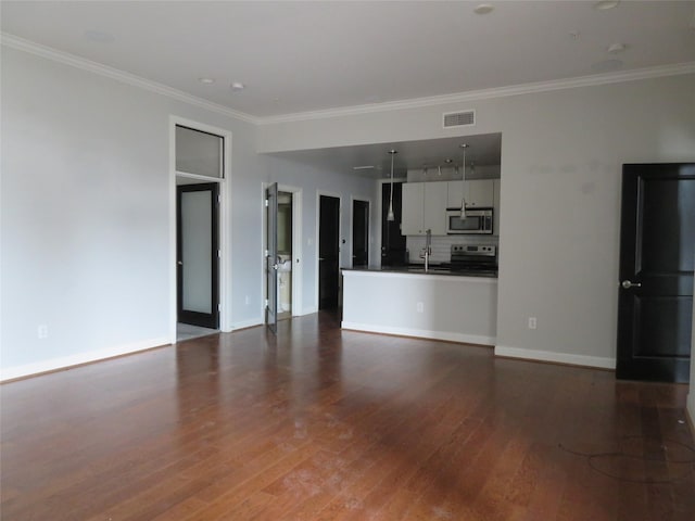 unfurnished living room featuring dark wood finished floors, ornamental molding, visible vents, and a sink