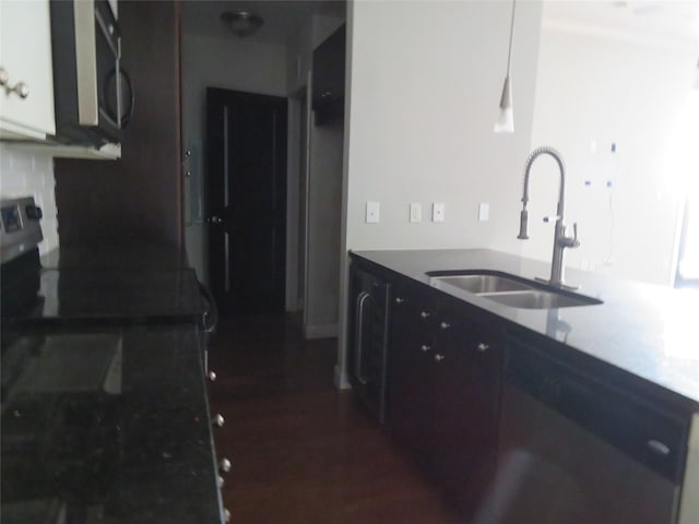 kitchen with a sink, stainless steel microwave, dark wood-style flooring, and electric range oven