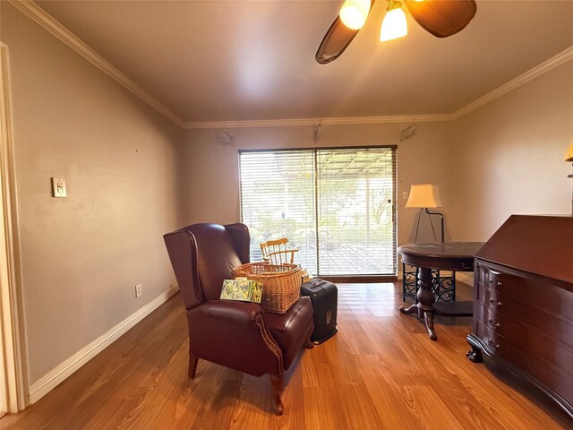 sitting room with crown molding, baseboards, ceiling fan, and wood finished floors