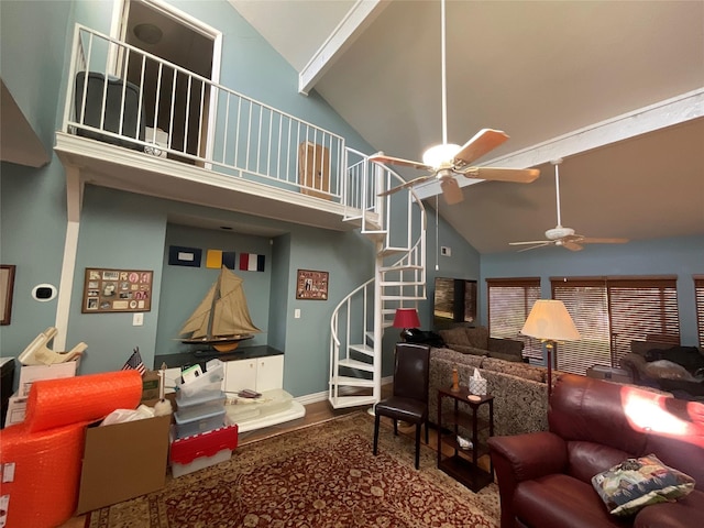 living area featuring ceiling fan, high vaulted ceiling, wood finished floors, baseboards, and stairway