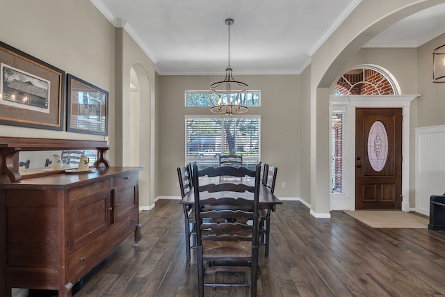 dining space featuring an inviting chandelier, crown molding, arched walkways, and dark wood-style flooring