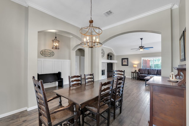 dining area with visible vents, ceiling fan with notable chandelier, arched walkways, and dark wood-style flooring