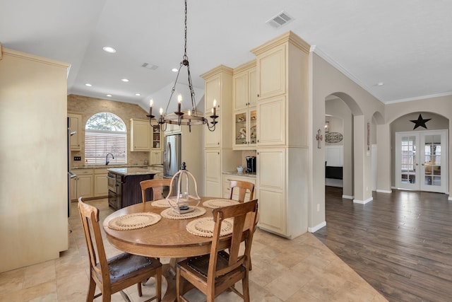 dining space with visible vents, arched walkways, vaulted ceiling, crown molding, and a notable chandelier