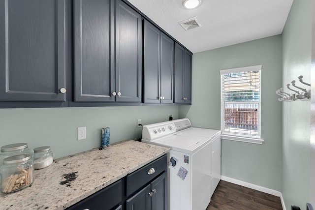 washroom with visible vents, washer and dryer, cabinet space, baseboards, and dark wood-style flooring