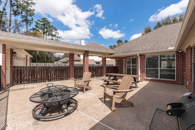 view of patio / terrace with outdoor dining area, fence, and an outdoor fire pit